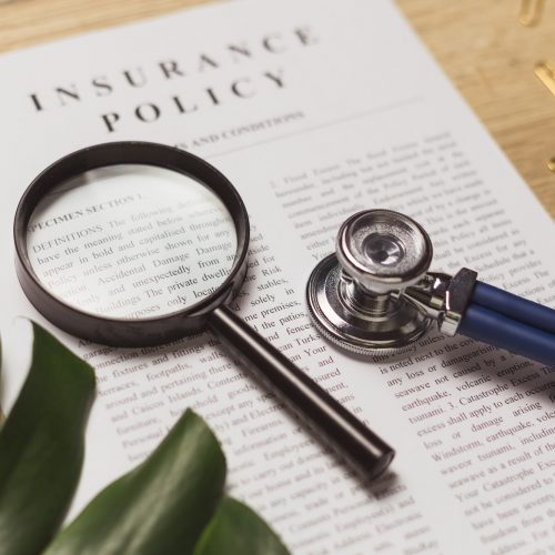 Health insurance. Doctor's stethoscope, magnifier and health insurance contract.